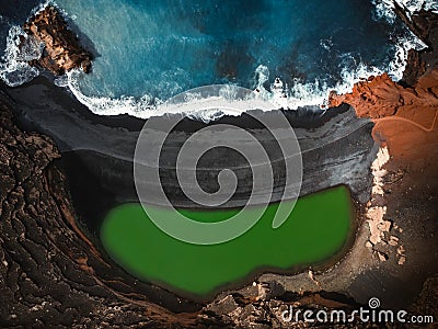 Aerial view of the El lago Verde Lanzarote - green lagoon with blue ocean - top view. Blue Atlantic ocean with waves and black Stock Photo