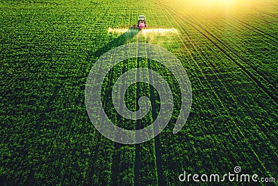 Aerial view of farming tractor plowing and spraying on field Stock Photo