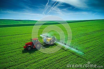 Aerial view of farming tractor plowing and spraying on field Stock Photo