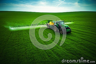 Aerial view of farming tractor plowing and spraying on field Stock Photo