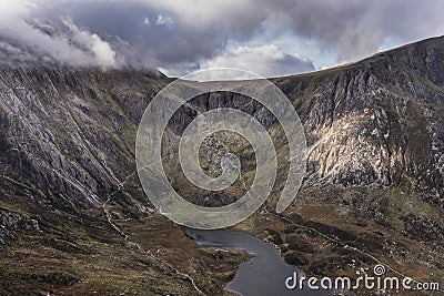 Aerial view of flying drone Epic dramatic Autumn landscape image of Llyn Idwal in Devil`s Kitchen in Snowdonia National Park with Stock Photo