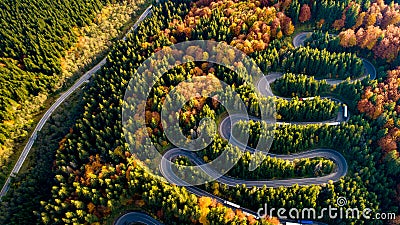 Aerial view of forest road in beautiful autumn .at sunset. Mountain roads details with colourful landscape with heavy traffic and Stock Photo