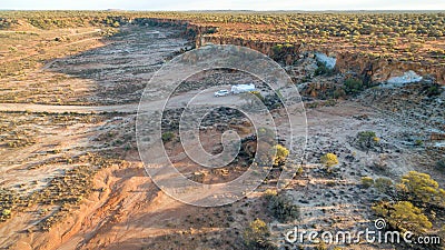 Aerial view of four wheel drive vehicle and large caravan camped near a cliff. Stock Photo
