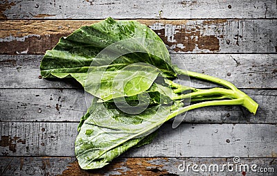 Aerial view of fresh collard chinese kale on wooden background Stock Photo