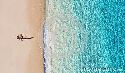 Aerial view of a girl on the beach on Bali, Indonesia. Vacation and adventure. Beach and turquoise water. Top view from drone at b Stock Photo