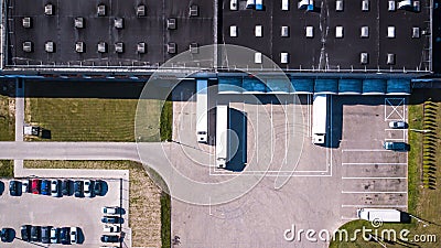 Aerial view of goods warehouse. Logistics center in industrial city zone from above. Aerial view of trucks loading at logistic cen Stock Photo