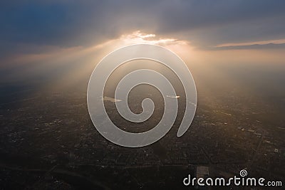 Aerial view from high altitude of distant city covered with puffy cumulus clouds forming before rainstorm in evening Stock Photo