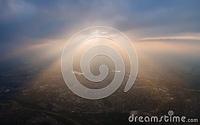 Aerial view from high altitude of distant city covered with puffy cumulus clouds forming before rainstorm in evening Stock Photo