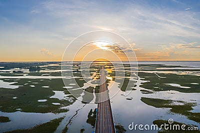 Aerial view of highway during sunrise in the middle of swamp Stock Photo