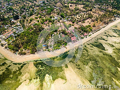 Aerial view of a huge coral reef table forming a fringing reef around a tropical island Stock Photo