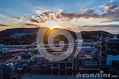 Aerial view Oil refinery with a background of mountains and sky at sunset. Stock Photo