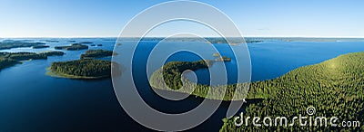 Aerial view of of islands on a blue lake Paijanne. Blue lake, islands and green forest from above on a sunny summer evening. Stock Photo