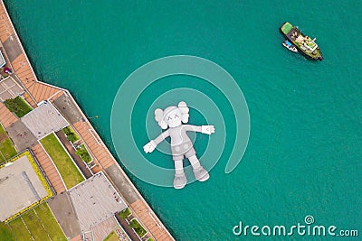 Aerial view of KAWS companion, giant sculpture floating on water. Figure in Victoria Harbour, Hong Kong. Republic of China Editorial Stock Photo