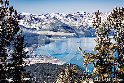 Aerial view of Lake Tahoe on a sunny winter day, Sierra mountains covered in snow visible in the background, California Stock Photo