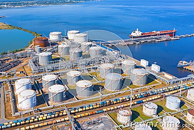 Aerial view of large fuel storage tanks at oil refinery industrial zone in the cargo seaport, and ship tanker at unloading Stock Photo