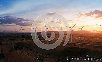 Aerial view of large wind turbines at sunset taken from the air. wind turbines farm park. Stock Photo