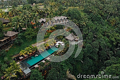 Aerial view of luxury hotel with straw roof villas and pools in tropical jungle and palm trees. Luxurious villa, pavilion in Stock Photo