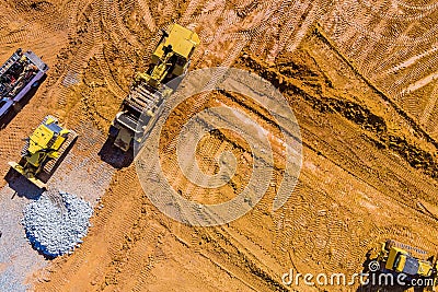 Aerial view machinery and heavy-duty equipments at large construction site of excavator, bulldozer, dump truck, digger Stock Photo