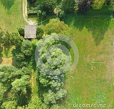 Aerial view of a meadow bordering a lawn, with a shed and several bushes and trees Stock Photo