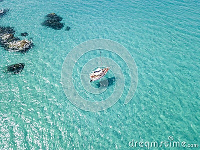 Aerial view of a moored boat floating on a transparent sea. Stock Photo