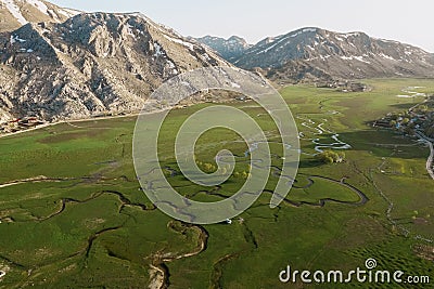 Aerial view of mountain meeting meadow with many paths Stock Photo