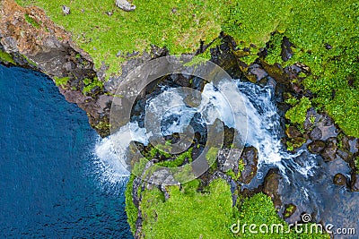 Aerial view of Mulafossur waterfall in Gasadalur village in Faroe Islands, North Atlantic Ocean. Photo made by drone from above. Stock Photo