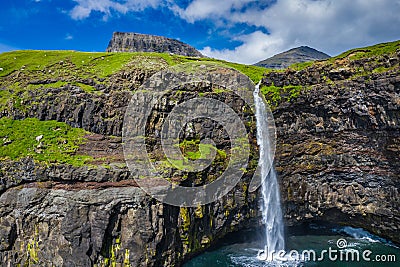 Aerial view of Mulafossur waterfall in Gasadalur village in Faroe Islands, North Atlantic Ocean. Photo made by drone from above. Stock Photo