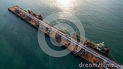 Aerial view oil tanker and oil storage tank terminal port at sunset Editorial Stock Photo