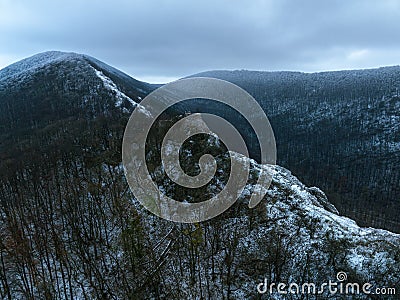 Aerial view of old ruins of fortress in the middle of winter forest. Drone view of snowy landscape with broken stone Stock Photo