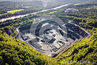 Aerial view of opencast mining quarry in the middle of the forest Stock Photo