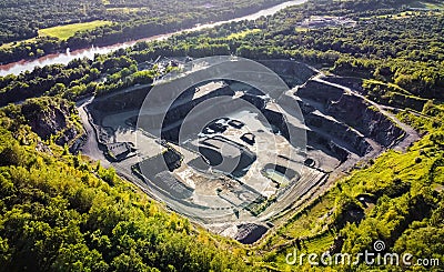 Aerial view of opencast mining quarry in the middle of the forest Stock Photo