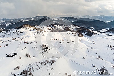 Aerial view over winter in the mountain village from Romania ,winter storm with low clouds and mist Stock Photo