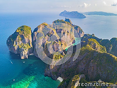 Aerial view of Phi Phi, Maya beach with blue turquoise seawater, mountain hills, and tropical green forest trees at sunset with Stock Photo