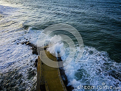 Aerial view of a pier with rocks. Pizzo Calabro pier, panoramic view from above. Broken pier, force of the sea. Power of Waves. N Stock Photo