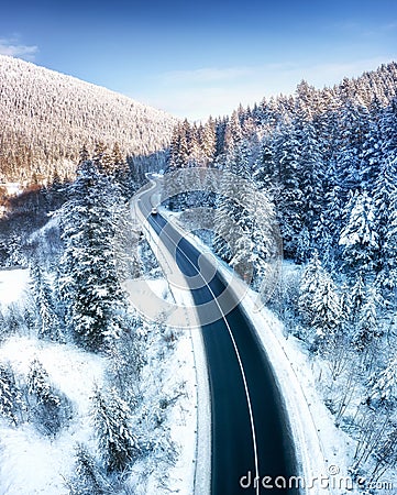 Aerial view on the road and forest at the winter time. Natural winter landscape from air. Forest under snow a the winter time. Stock Photo