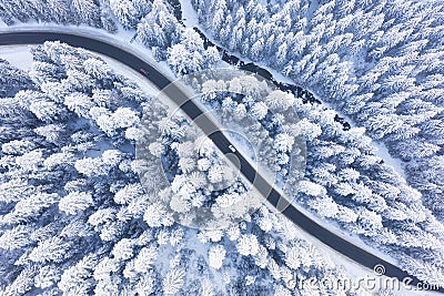 Aerial view on the road and forest at the winter time. Natural winter landscape from air. Forest under snow a the winter time. Stock Photo