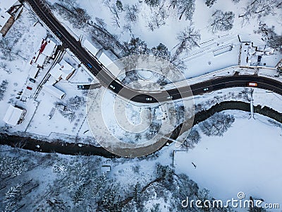 Aerial view of road and river in small town with snow covered houses. Stock Photo