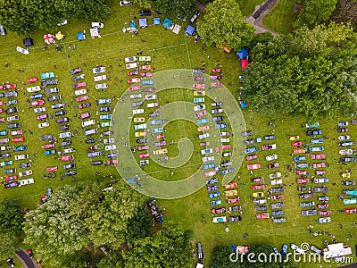 Aerial view of rows of parked colorful cars at lush green campsite Stock Photo