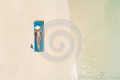 Aerial view of slim woman sunbathing lying on a beach chair in Maldives. Summer seascape with girl, beautiful waves, colorful Stock Photo