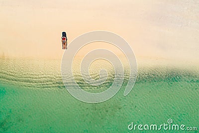 Aerial view of slim woman sunbathing lying on a beach chairin Seychelles. Summer seascape with girl, beautiful waves, colorful Stock Photo