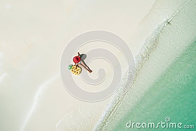 Aerial view of slim woman swimming on the transparent turquoise sea. Summer seascape with girl, beautiful waves, colorful water. Stock Photo