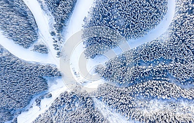 Aerial view at the slope on ski resort. Forest and ski slope from air. Winter landscape from a drone. Snowy landscape on the ski r Stock Photo