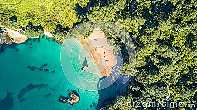 Aerial view on a small beach surrounded by rocks and forest. Coromandel, New Zealand Stock Photo