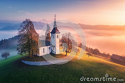 Aerial view of small church on the hill and low clouds at sunrise Stock Photo