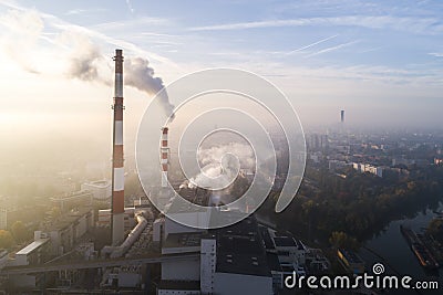 Aerial view of smoking chimneys of CHP plant and smog over the city and builidings in the background Stock Photo