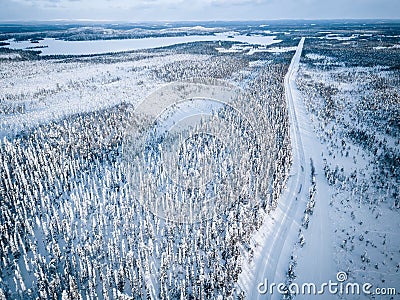 Aerial view of snow covered winter forest and road. Beautiful rural landscape in Finland Stock Photo