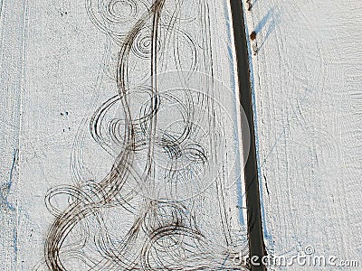 Aerial view of snow fields splitted by tar road with lines of offroad car in field Stock Photo