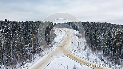 Aerial view of forest covered with snow, road in winter time Stock Photo