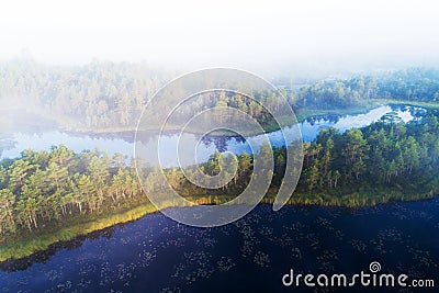 An aerial view of foggy morning in Mukri bog in Estonia with some small bog lakes and islands in Northern Europe. Stock Photo