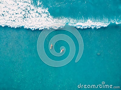 Aerial view of surfers and wave in tropical ocean. Top view Stock Photo